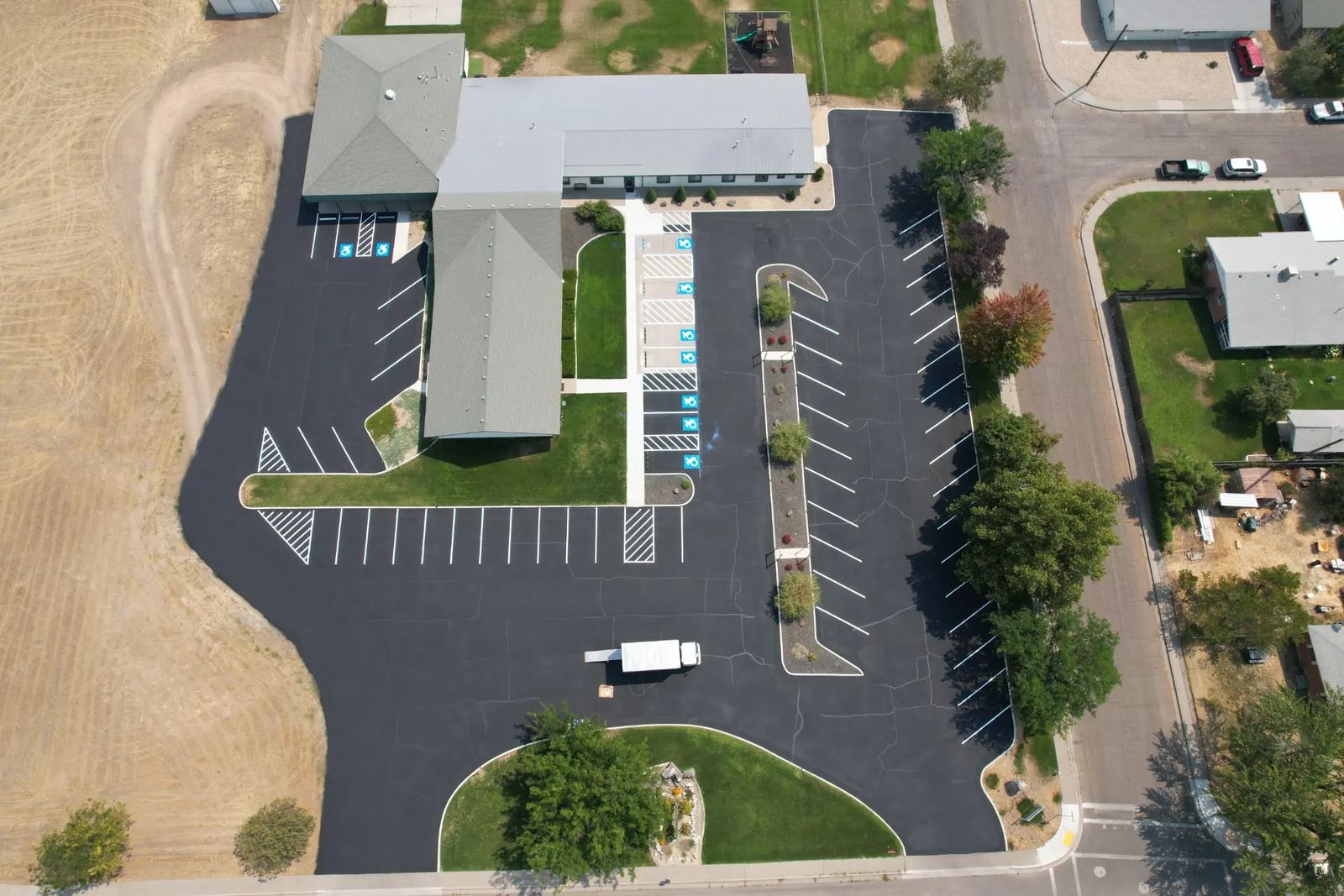 Aerial view of a church parking lot after sealcoating and striping by Supreme Seal Coat in the Treasure Valley