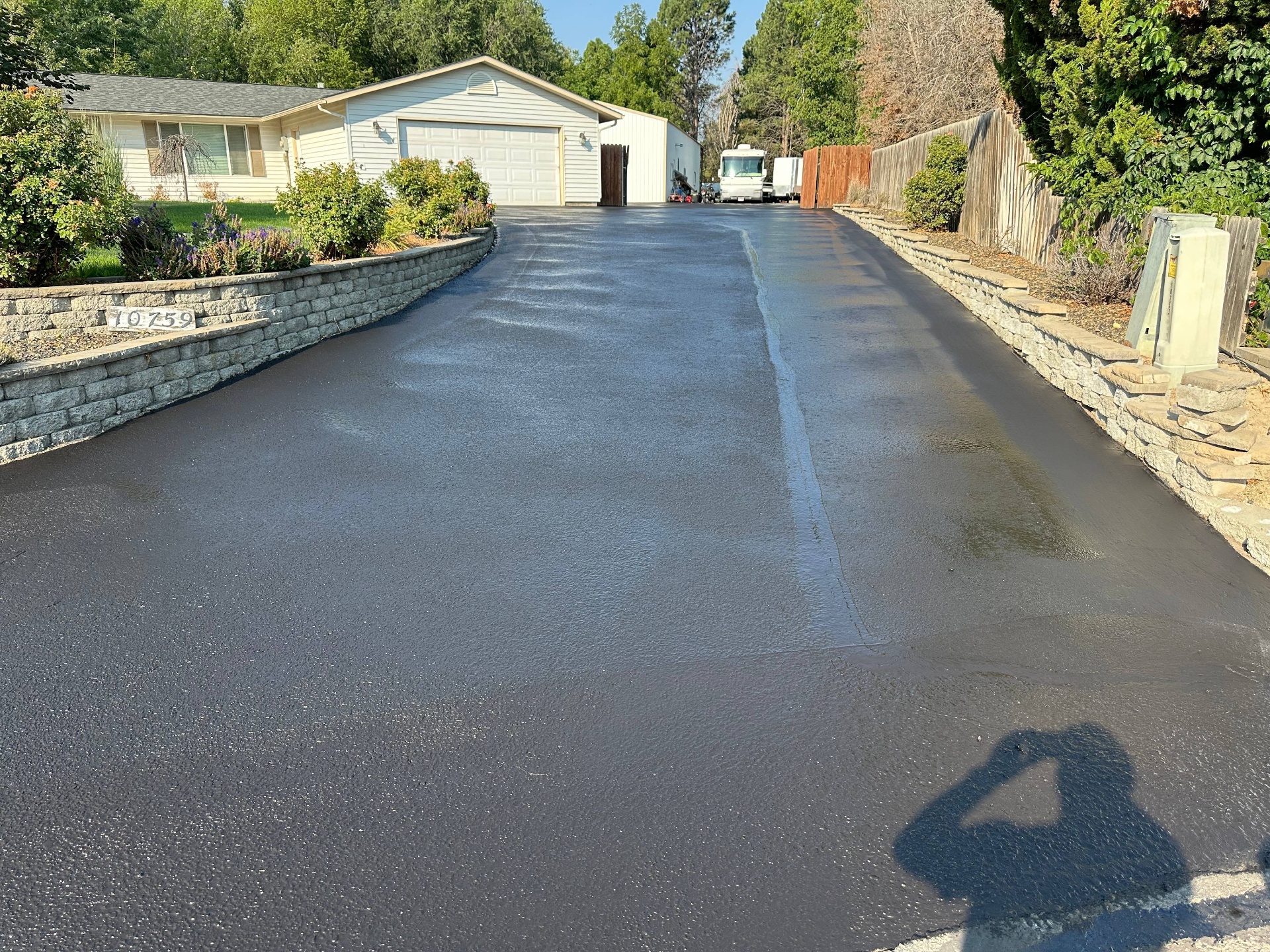 Suburban home with a freshly sealed black asphalt driveway by Supreme Seal Coat