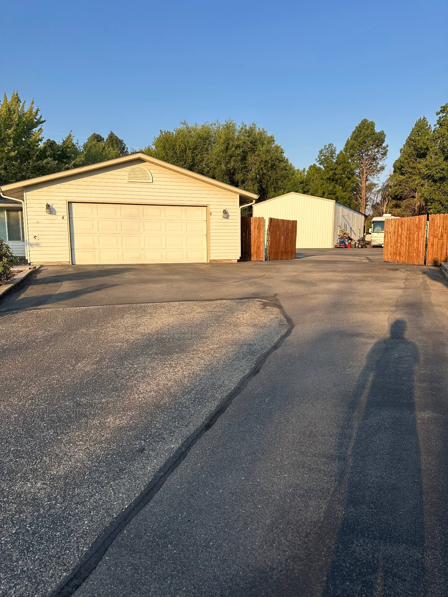 Residential driveway with two-car garage after sealcoating by Supreme Seal Coat