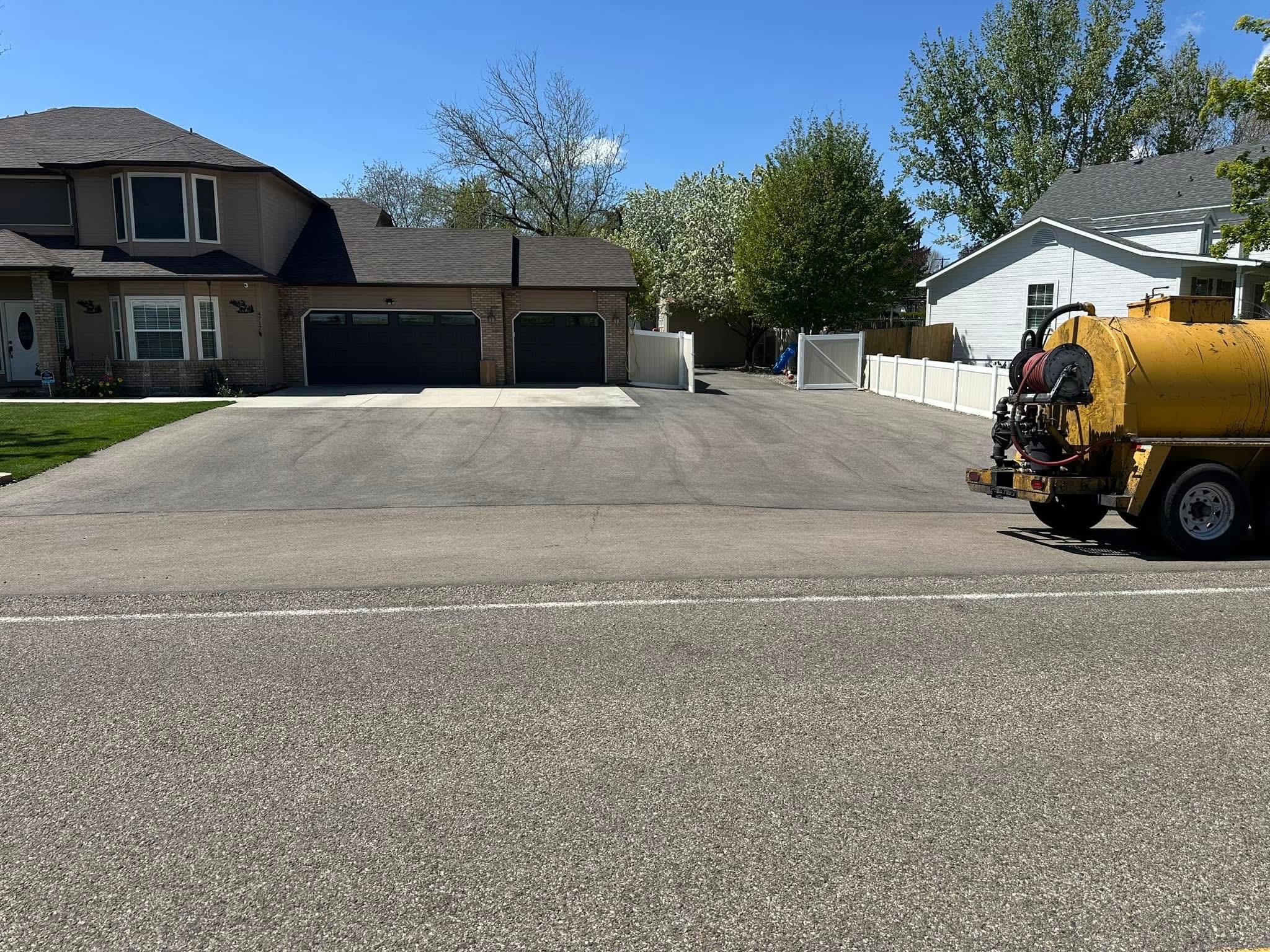 Treasure Valley home with a freshly sealcoated driveway viewed from the street