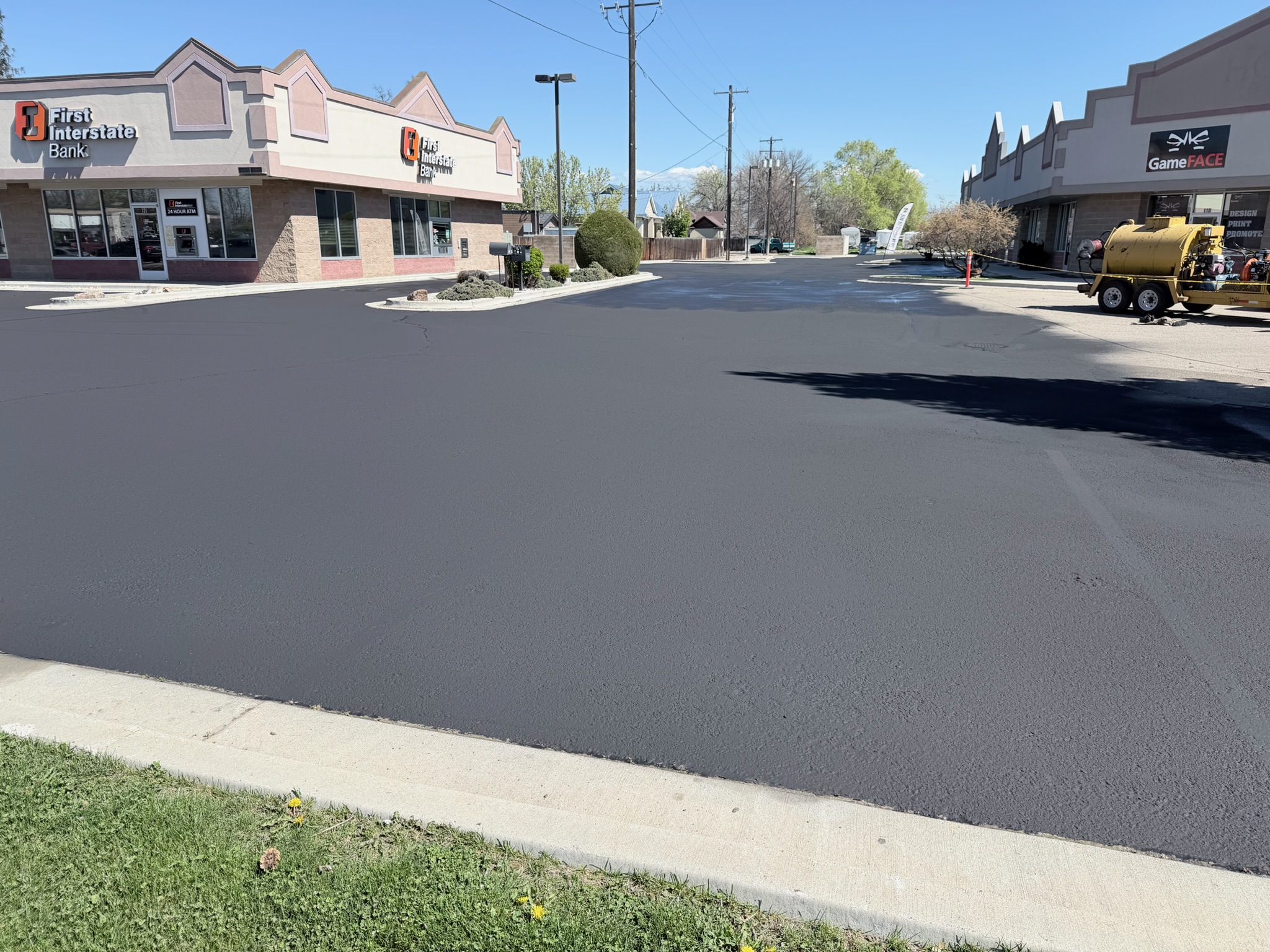 Wide view of the freshly sealcoated and striped plaza lot in Meridian, Idaho