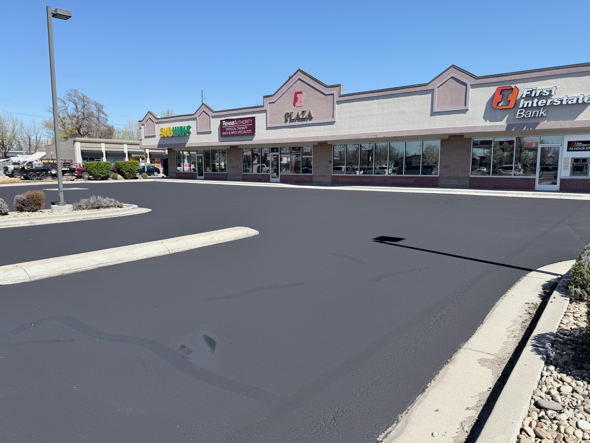 Subway and H&R Block storefronts with the freshly striped parking lot in front